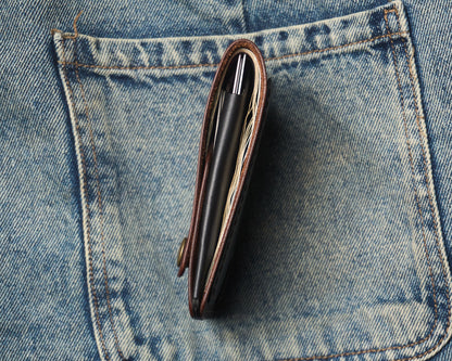Side profile of a slim everyday carry (EDC) leather wallet filled with cards and cash, demonstrating its thin profile inside a denim jeans pocket.