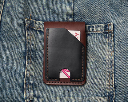 Back view of a two-tone leather wallet resting on blue jeans, featuring a quick-access black leather card slot with hand-stitched detailing.